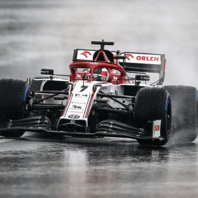 Kimi Räikkönen kör i regn i en kurva.