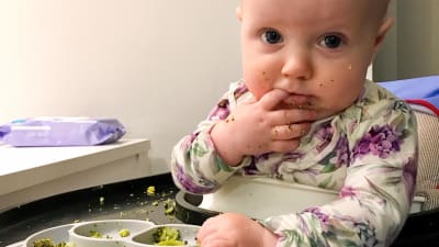 en ettåring äter broccoli med egna händer