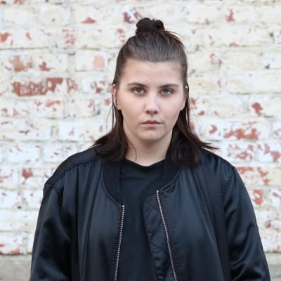 Hanna Lagerström framför en tegelvägg.