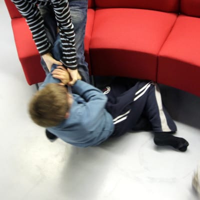 Lapset tappelevat latttialla.