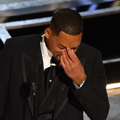 Will Smith håller handen för ögonen på Oscarsgalan.