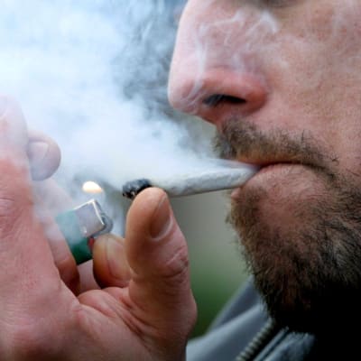Man tänder en cannabiscigarett.
