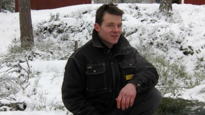 Daniel Eriksson sitter vid en grillplats utsomhus på vintern