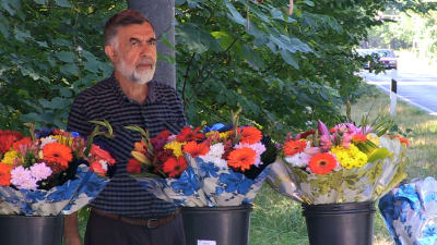 Ali Toy säljer blommor på den plats där hans chef mördades.