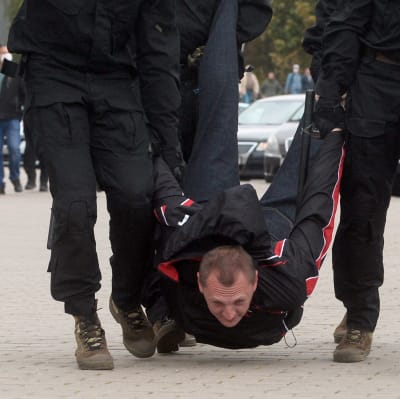 Belarusisk polis tar till krafttag mot protesterna och bär en demonstrant 27 september