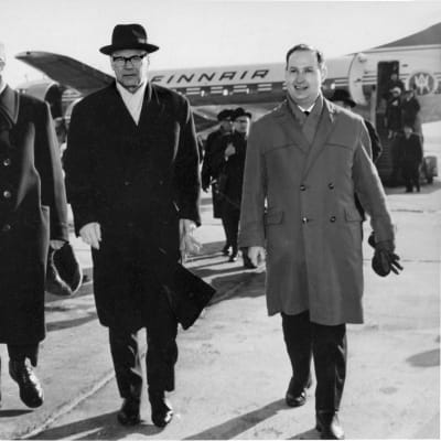 Kekkonen anländer till Tallinns flygplats den 11 mars 1964. På hans högra sida ordföranden i Estlands Högsta sovjets presidium Aleksei Müürisepp. TIll vänster om Kekkonen tolken Hillar Laane.