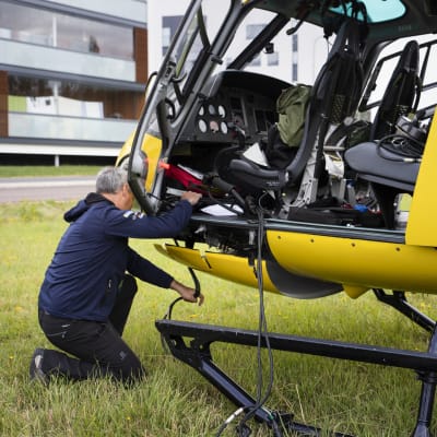 Bart Van Aert kiinnittää kuvauskalustoa helikopteriin. 