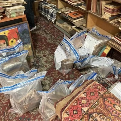 Böcker beslagtagna av Europol i plastpåsar för bevismaterial. Bokpåsarna är uppradade på en matta intill en bokhylla. 