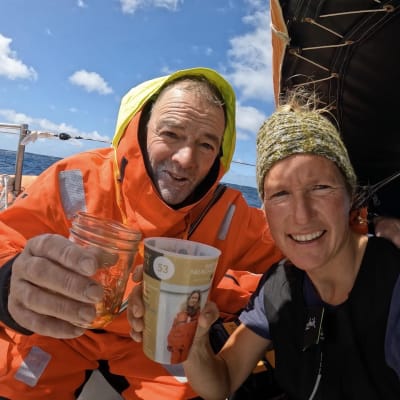 Tapio Lehtinen och Kirsten Neuschäfer håller i var sitt glas ombord en segelbåt.