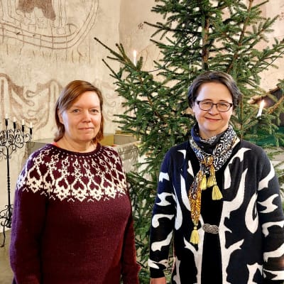 två kvinnor vid en julgran i kyrka