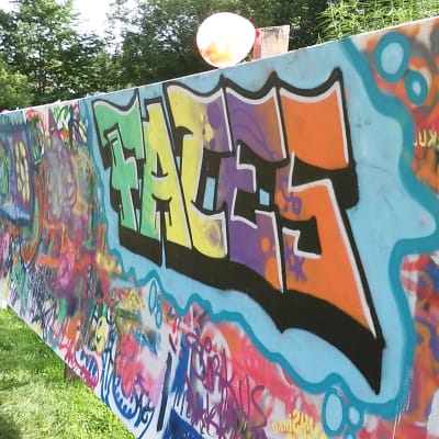 En grafittivägg där det står Faces med färggranna bokstäver.