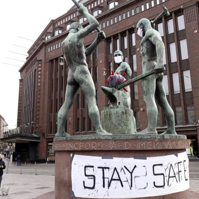Kolmen sepän patsas sai korona-päivityksen Helsingissä 30. maaliskuuta.