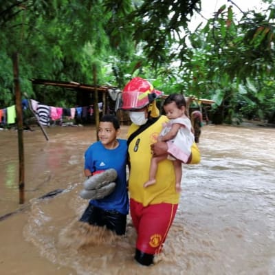 Pelastustyöntekijät auttavat ihmisiä hurrikaani Etan aiheuttaman tulvan keskellä.