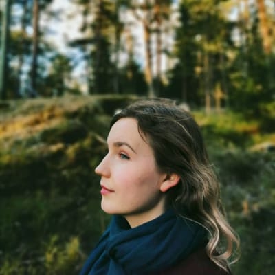 Julia Sangervo seisoo metsikön edustalla. 