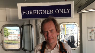MAn på båt i bakgrunden skylt -foreigner only