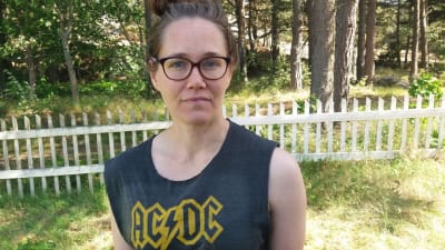 kvinna står på gräsplan vid staket med ac/dc skjorta