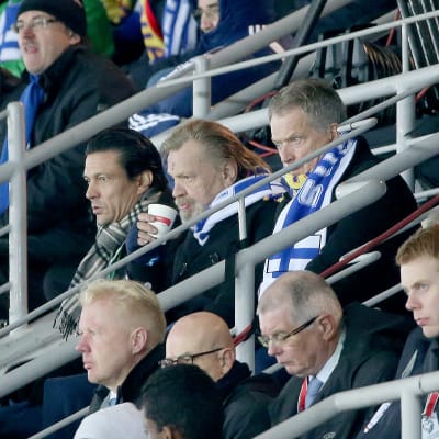 Jari Litmanen, Vesa-Matti Loiri och Sauli Niinistö följer med en fotbollsmatch.
