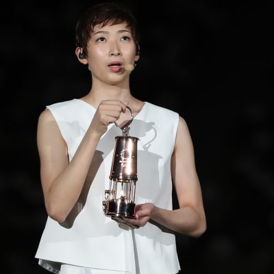 Rikako Ikee håller upp en trofé i samband med OS-festlighet.