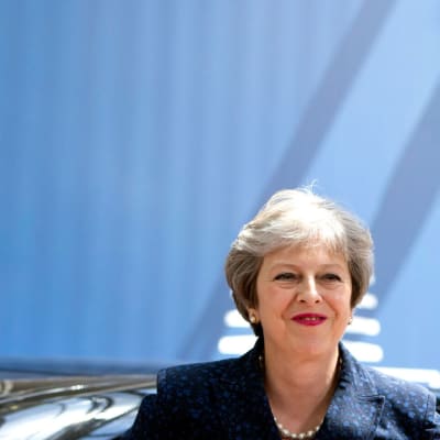 STheresa May med en EU-flagga bakom sig