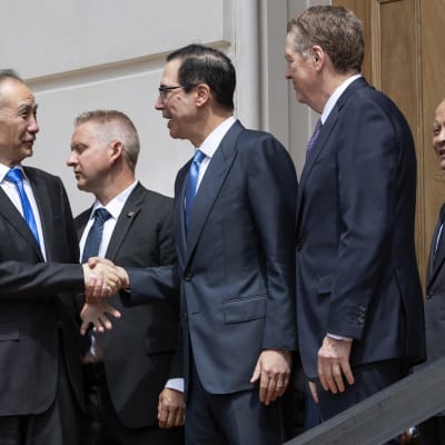 Kiinan ja Yhdysvaltojen neuvottelijat kättelevät toisiaan portaissa Washingtonissa. 