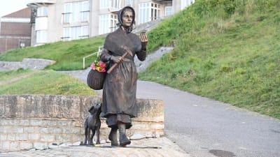 Staty av fossilletaren Mary Anning och hennes hund.