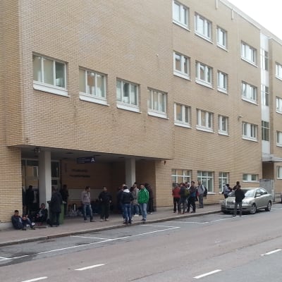 Ett gäng asylsökande utanför polisstationen i Åbo.