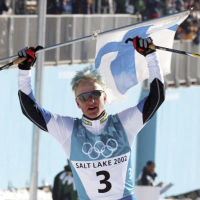 Samppa Lajunen juhlii olympiakultaa hiihtäen maaliin.