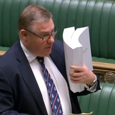 Den konservativa parlamentsledamoten Mark Francois håller en kopia av handelsavtalet medan han deltar i debatten om underhuset den 30 december 2020.