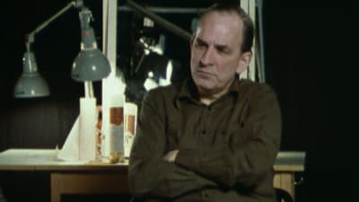 Närbild på Ingmar Bergman som sitter på en stol framför en spegel.