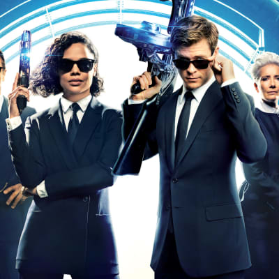 De hemliga agenterna (Liam Neeson, Tessa Thompson, Chris Hemsworth och Emma Thompson) i Men in Black poserar med vapen.