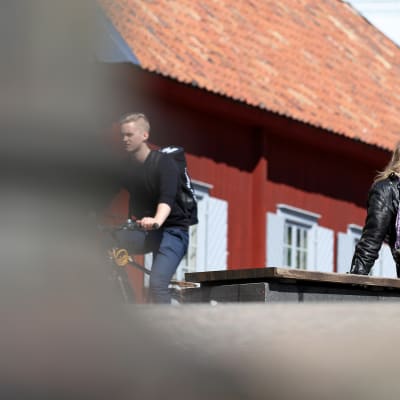 Mies nauttii auringosta Turun jokirannassa.