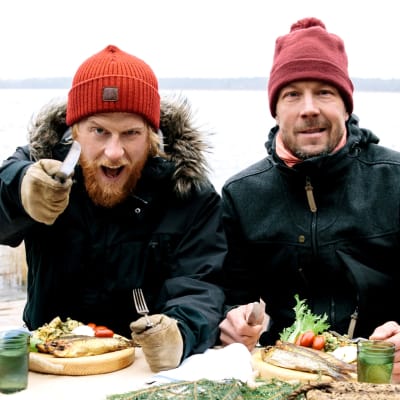 Tom Nylund ja Mikko "Peltsi" Peltola Itämeren äärellä kala-annosetn kanssa pipot päässä.