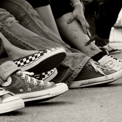 Ungdomars skor på svartvit bild.