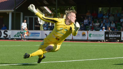 Fotbollsmålvakt kastar sig mot marken.