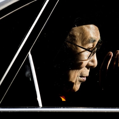 Tiibetin hengellinen johtaja Dalai Lama vilkuttaa autosta Hollannissa.