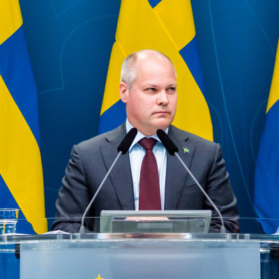 Morgan Johansson med Sveriges flaggor i bakgrunden.
