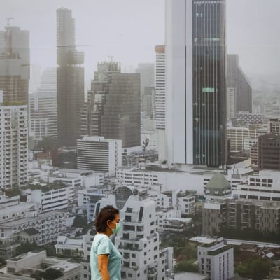Nainen pitää hengityssuojainta Bangkokin saasteiden keskellä.