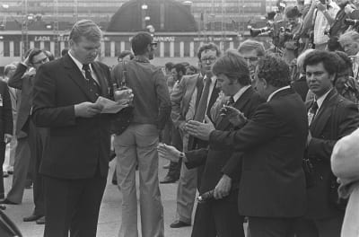 Neuvostoliiton pääministeri Leonid Brezhnev saapuu Helsingin rautatieasemalle, ulkoministeriön lehdistöpäällikkö Reino Paasilinna selvittää toimittajien ja turvamiesten kanssa asemalaiturilla tiedotustilaisuuden järjestelyjä.