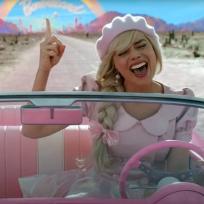 På bilden en blond kvinna iklädd en rosa basker och håret i en fläta. Hon kör en rosa bil utan tak. 