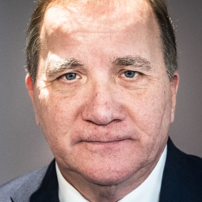 En man i kostym och slips tittar in i kameran.