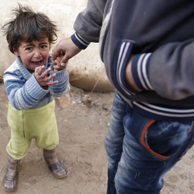 Syyrialaislapsi itkee pakolaisleirillä.