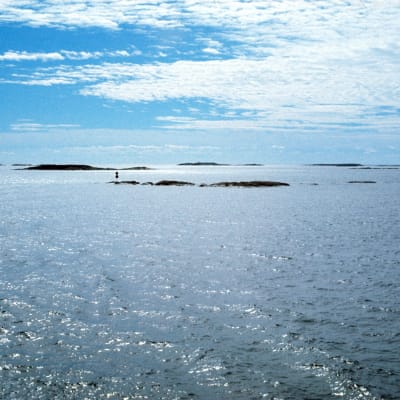 En bild på ett blått hav, kobbar och skär och blå himmel.