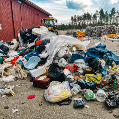 Muoviroskaa iso kasa kierrätysterminaalin pihalla Pyhäjoella: muovikasseja, kanisteri, lasten vanna ja pressuja.