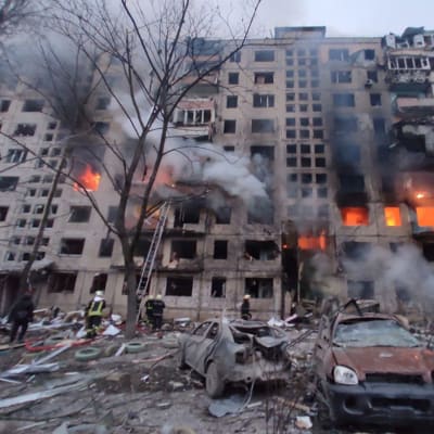 Branmän försöker släcka en brand i en sönderbombat höghus