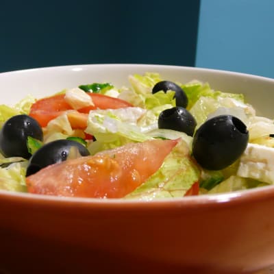Mustat oliivit koristavat salaattiannosta.
