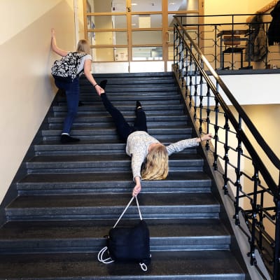 Kuvassa kaksi oppilasta koulun portaissa.