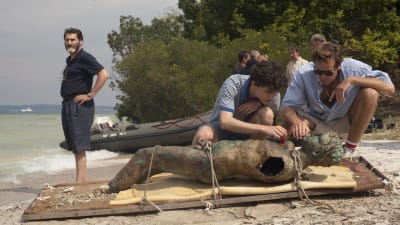 Elio (Timothée Chalamet) och Oliver (Armie Hammer) undersöker en staty som de dragit upp ur en sjö. Vid sidan ser man Elios far (Michael Stuhlbarg).