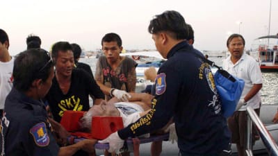 Räddningsarbetare bär en skadad turist.