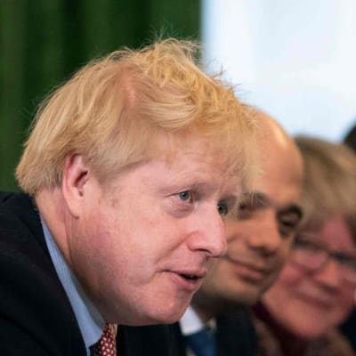 Boris Johnson sitter vid ett bord med sina regeringskolleger på bägge sidor.