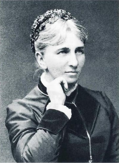 Svartvitt porträtt på kvinna i svart klänning med hög krage.